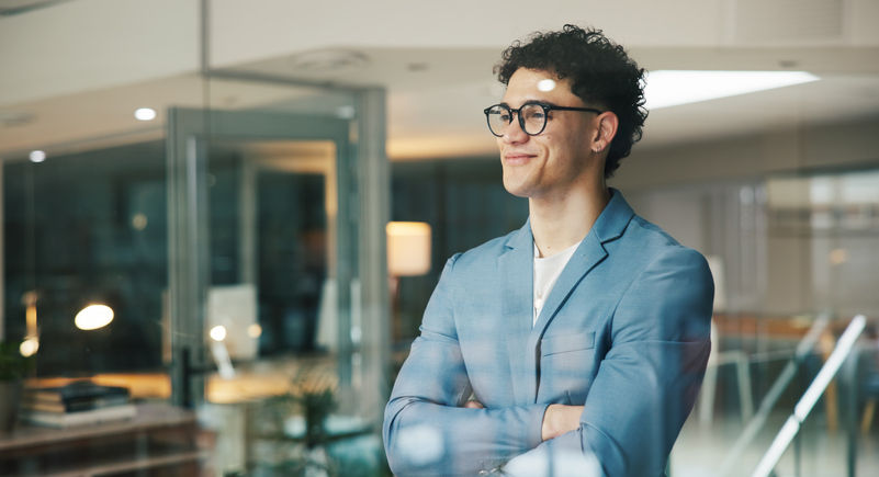Young Business man looking through a pane glass smilling