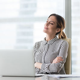 Smiling female boss relaxing in office chair with eyes closed