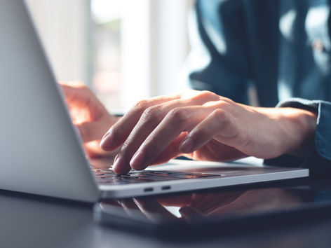 Close up of the hands of a person working on a computer