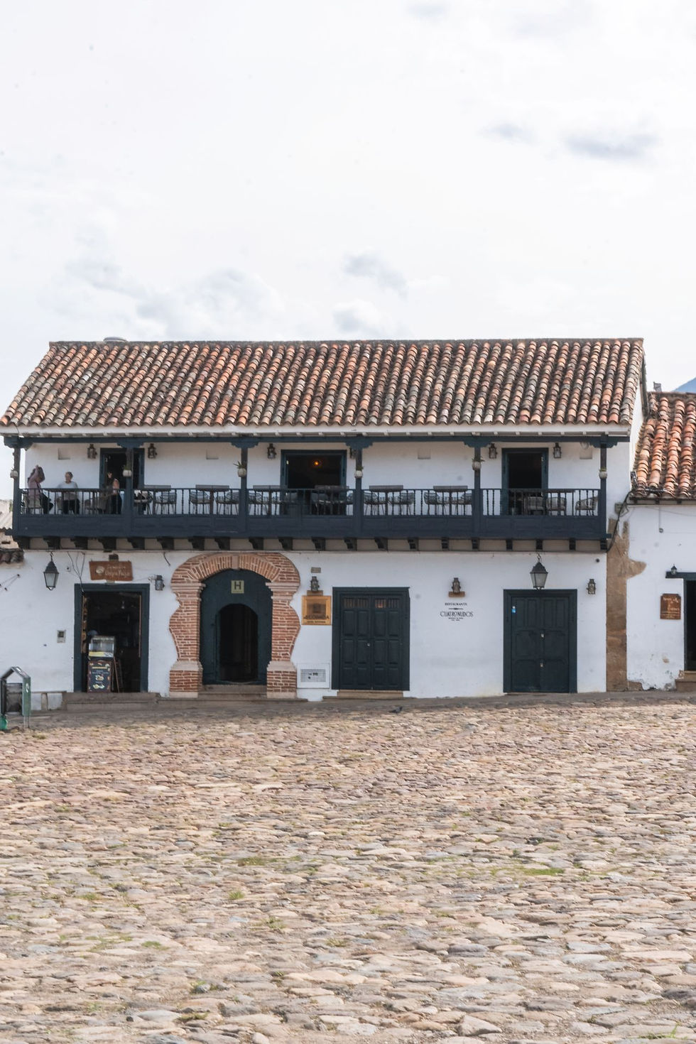 Eye-level view of cobblestone street with colonial buildings in Villa de Leyva
