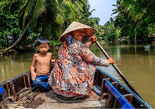 Místní obyvatelka s dítětem na lodi v deltě Mekongu ve Vietnamu.