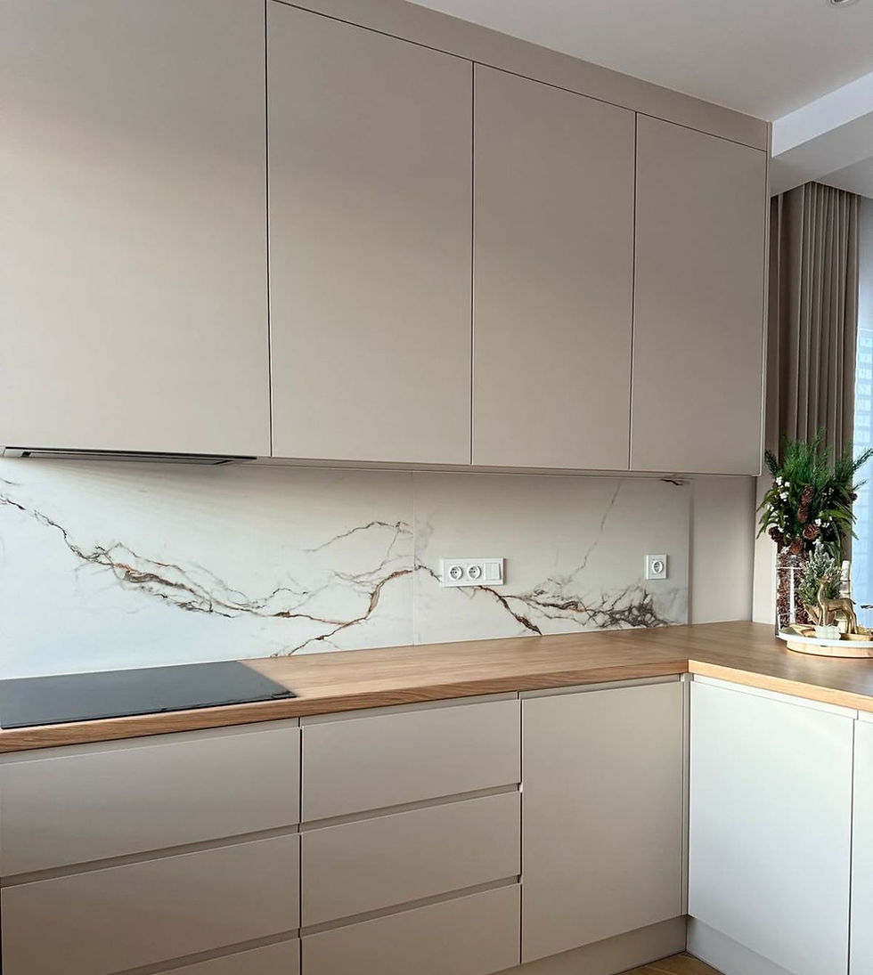 Modern kitchen with beige cabinets and marble backsplash. Wooden countertop with black stove. Potted plant on the right adds greenery.