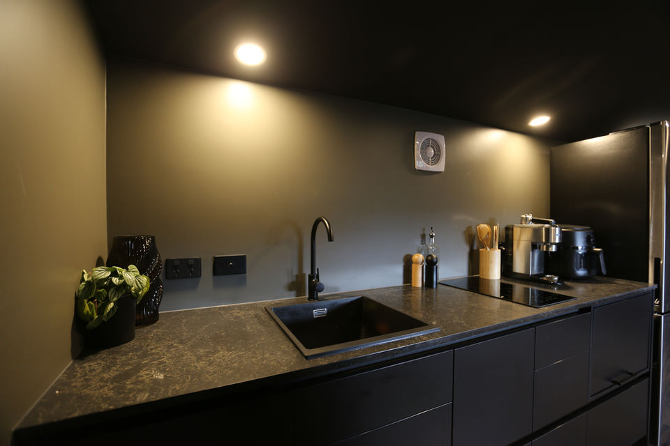 Fully black minimalist small kitchen in a granny flat
