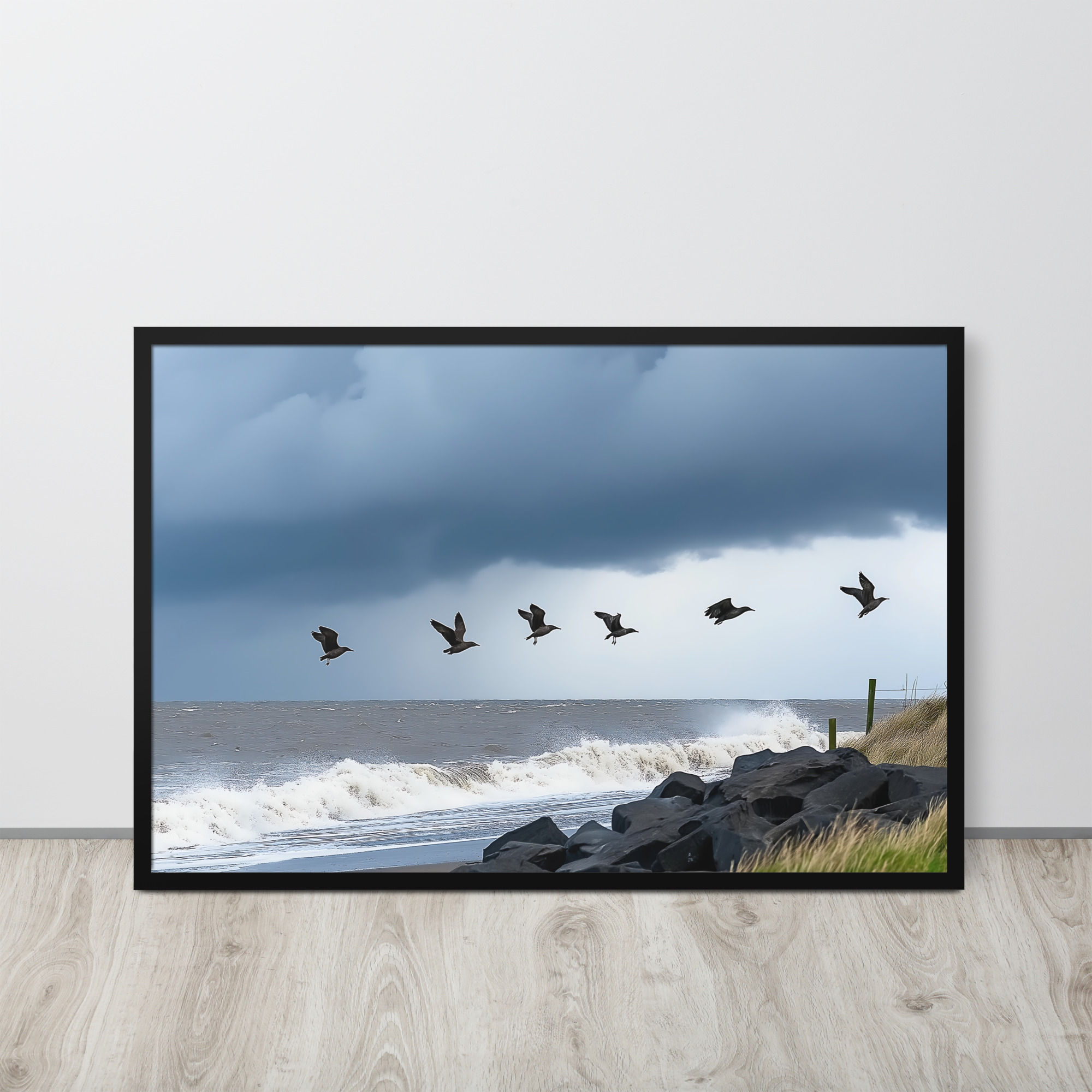 Flock of birds flying over a stormy sea.