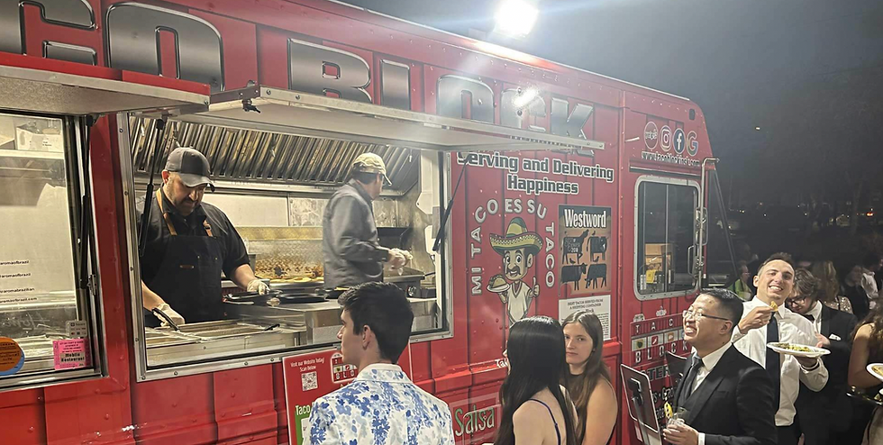 Image of Taco Block's food truck with customers surrounding.