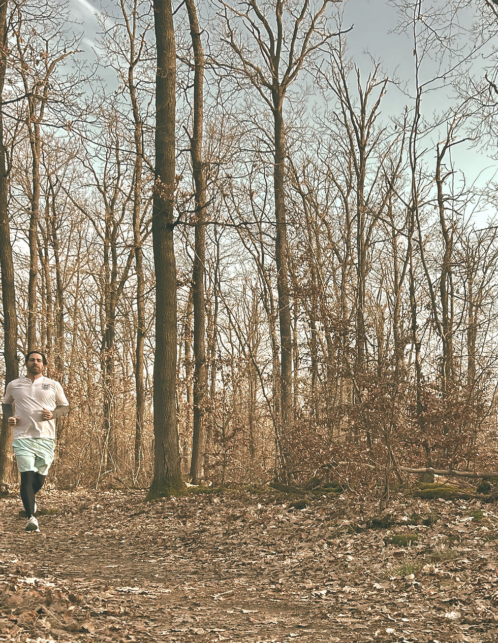Joggender Mann im Wald bei blauem Himmel