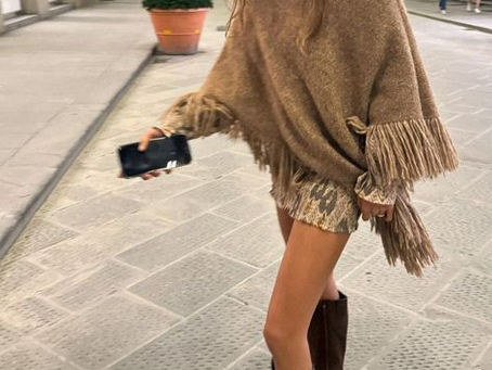 modest woman walking in a shawl type jumper.