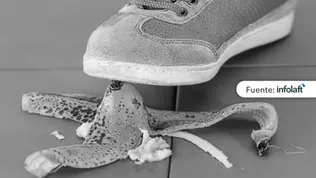 Zapatilla pisando una cáscara de banano sobre el suelo, representando un riesgo o accidente.