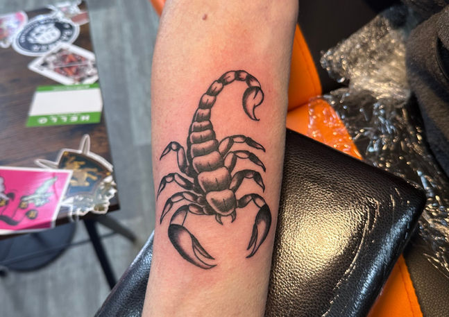 Small black and grey tattoo of a scorpion, placed on the inner forearm. Done by Ryan Evans.