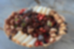 Dessert board with chocolate covered strawberries, brownie bites, chocolate chip cookie chunks, fruit tartlets and cannoli
