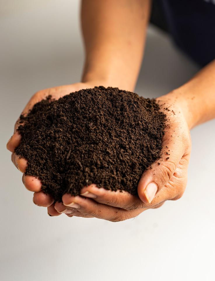 person holding compost mix bag's contents