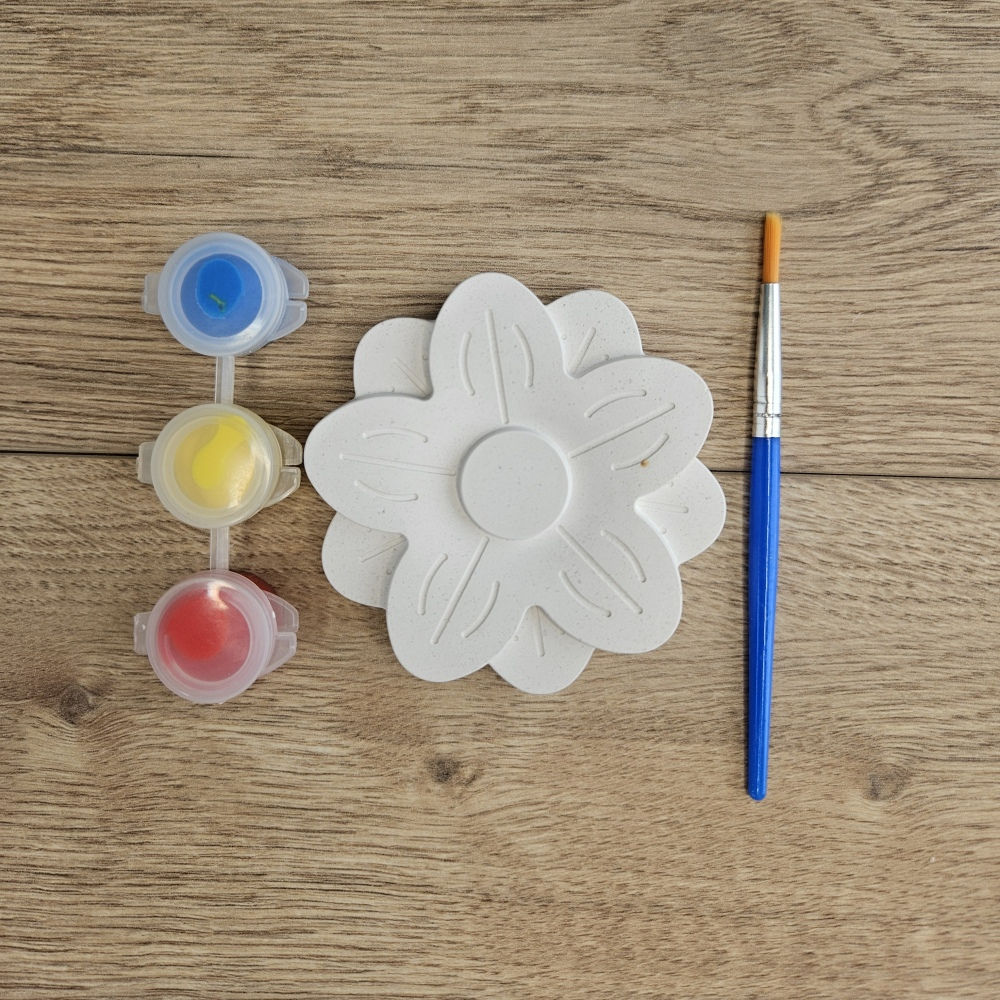 Flower Garden kids craft kit with a plaster shape, paints and brush on a wooden table