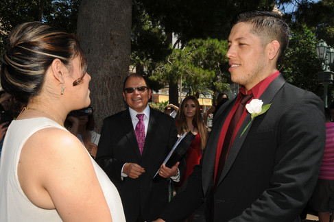 Ministro de boda llevando a cabo una ceremonia de bodas en la fuente del bellagio en las vegas mientras los novios transcurren el momento tomados de la mano 