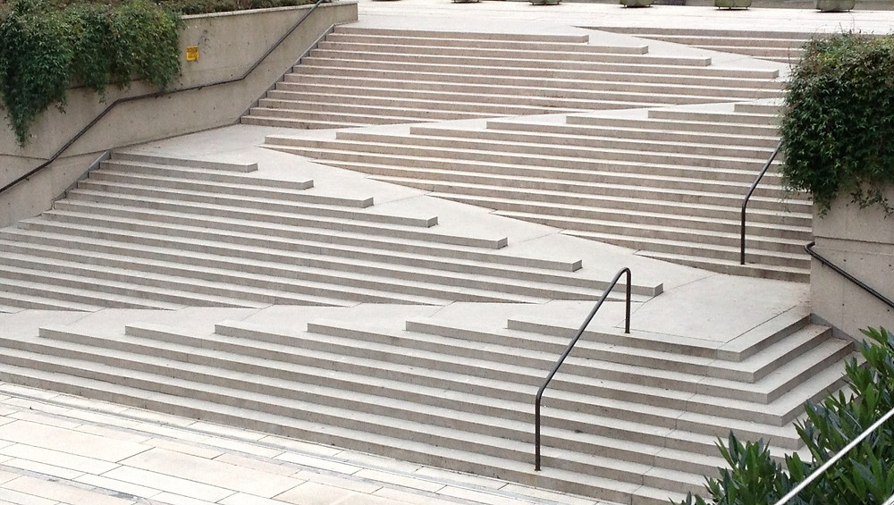 An architectural design that weaves together stairs and a ramp in a zig-zag pattern.