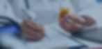 Medical Personnel wrtting down a prescription holding a bottle of medications