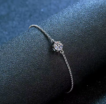 سوار فضي فاخر مع ماسة لامعة على سطح أزرق. Diama Luxury