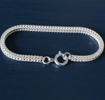 سوار فضي لامع بتصميم شبكي مميز، يظهر تفاصيله الدقيقة. Diama Luxury