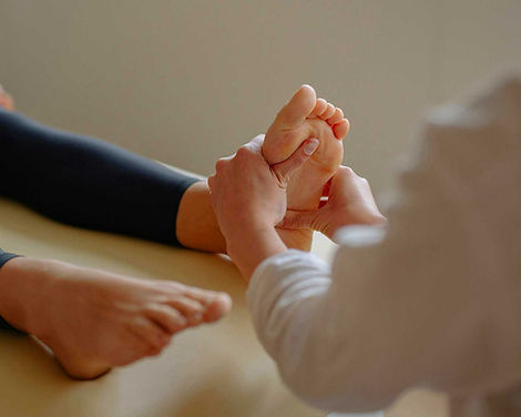 Hands performing a foot reflexology massage on a client at Zenvida wellness center in Madrid