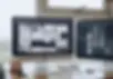 Two monitors displaying web design layouts on a desk