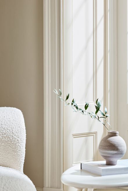 white walls with a boucle chair and side table.