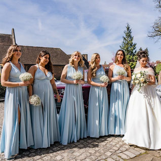 Exterior shot of bridesmaids and bride after a church ceremony