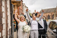 Joyful lesbian wedding couple celebrating with friends