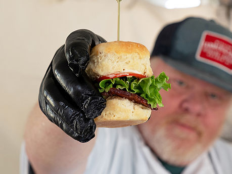 Chef Holding a BLT Slider Up Close