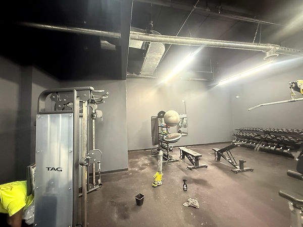 Open gym floor with exercise machines and clean painted walls