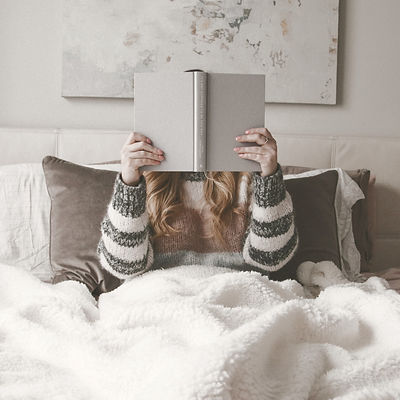 woman%20sitting%20on%20bed%20while%20holding%20book_edited.jpg