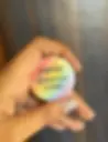 Hand holding rainbow button: Everyone deserves a voice