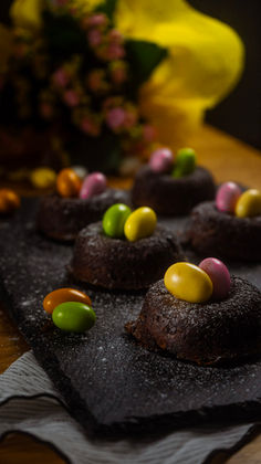 "Torta Caprese versione donut al caffè su vassoio di ardesia con ovetti di Pasqua colorati, dolce senza farina fatto in casa