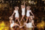 Five teenage girls in matching costumes posing together after a dance performance