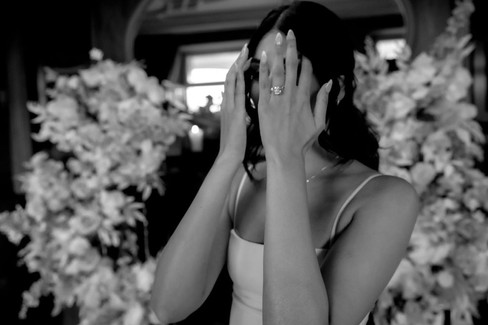 Woman covers her face in awe with her new engagement ring after marriage proposal at the cigar room in Villa Honegg, Switzerland