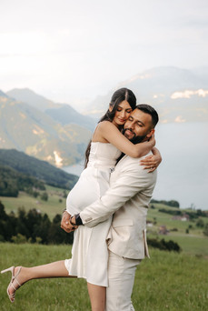Couple hugging in front of the lake and mountains in front of the hotel Villa Honegg on their marriage proposal photoshoot, in Switzerland