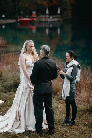 Bride and groom with officiant during their vows renewal ceremony at the Blausee