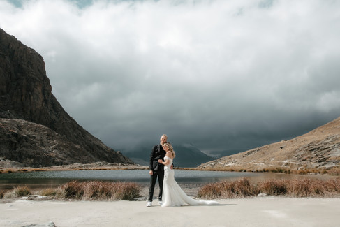 couple posing holding each other by a lake in gornergrat in zermatt
