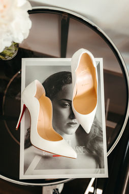 louboutin wedding shoes on a table at dolder grand hotel in Zurich.Wedding cake cutting with couple posing in front of it at hotel villa honegg.This wedding picture is part of the portfolio of the destination wedding and elopement photographer based in Switzerland and Italy Gloria Velvet. Vogue wedding photographer. 