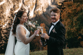 Close up of bride and groom cheering with champagne glasses elopement in the mountains in the alps in Murren, Switzerland toast