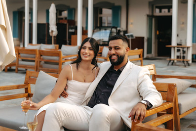 Couple smiling sitting on a bench and drinking champagne after their proposal at hotel Villa Honegg in Switzerland 