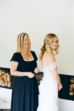 bride's mum helping the bride getting dresses smiling 35mm film in Zermatt