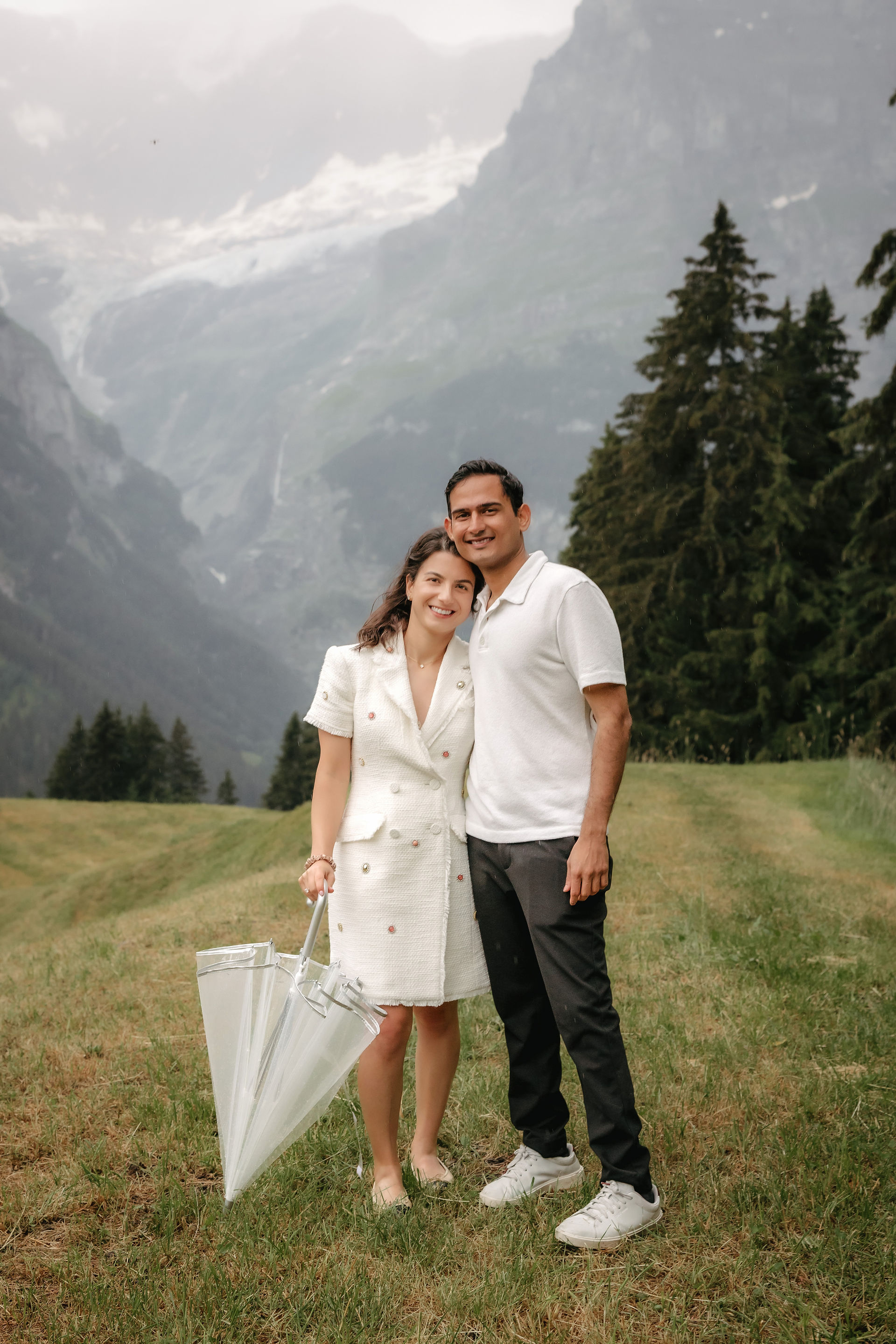 Adventurous proposal in Grindelwald Bort, at a private location in front of the Eiger. Couple posing together with umbrella. 