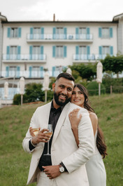Couple smiling and holding each other in front of the hotel Villa Honegg on their marriage proposal photoshoot, in Switzerland