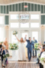 Bride and Groom, Callie and Brandon, walk down the isle after getting married at the Chesapeake Bay Beach Club. Photo courtesy of Tara Card Photography. 