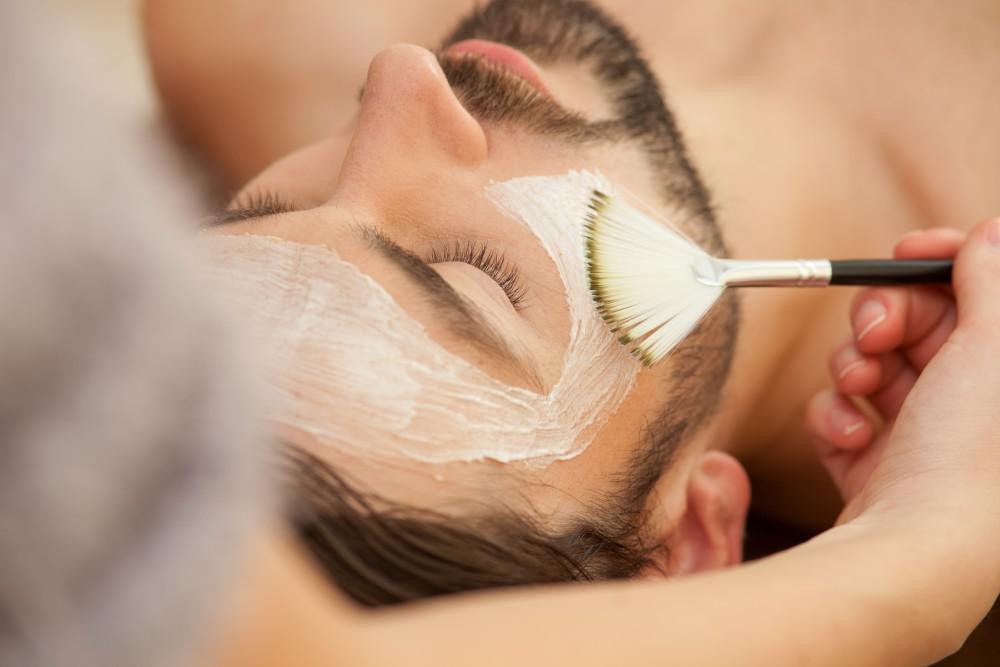Man with a beard and mustache receiving a facial