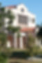 Gulf Coast Library. White stucco building with a red clay roof, trees to the front.