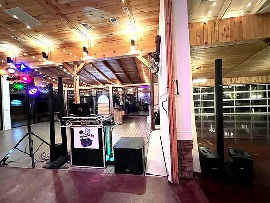 Beautiful Birmingham, AL wedding venue interior at night with a glowing lit dance floor and guests celebrating at a reception by DJ Mark of With Class Weddings