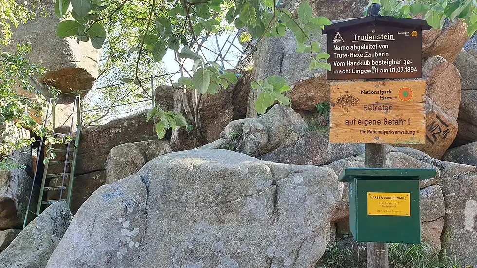 Wanderwegschild Judensteine warnt: Zutritt auf eigene Gefahr! inmitten Felsen.