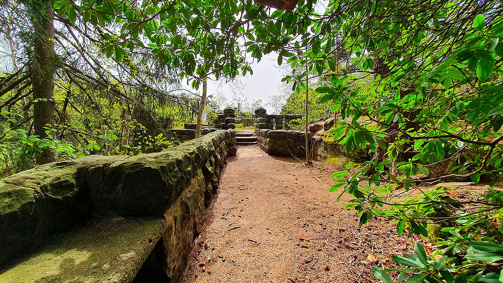 Stone wall with stairs leading upward Pfaffenstein and trees in background.