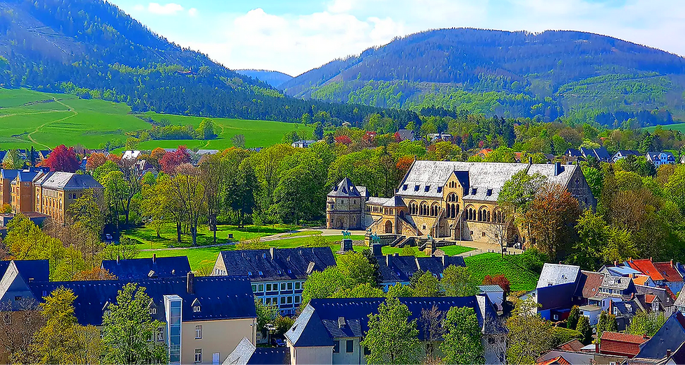 Historisches Gebäude umgeben von grünen Wäldern und Bergen im Harz.