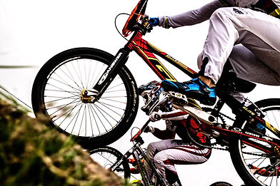 Zwei Trial-Biker springen dynamisch mit ihren Fahrrädern über Hindernisse.